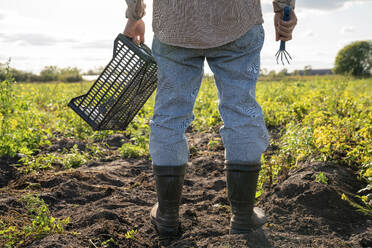 Landwirt mit Kiste und Handrechen auf dem Feld - VPIF09287