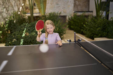 Lächelndes Mädchen spielt Tischtennis in einer Villa - ANNF00812