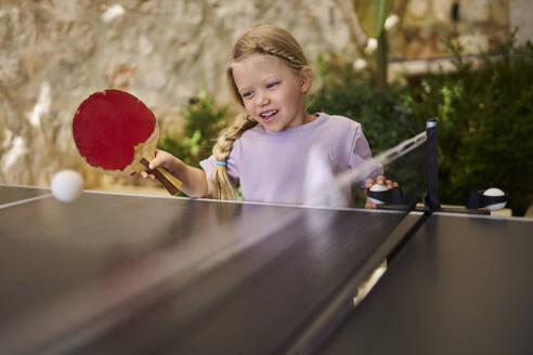 Mädchen hat Spaß beim Tischtennis spielen in einer Villa - ANNF00816