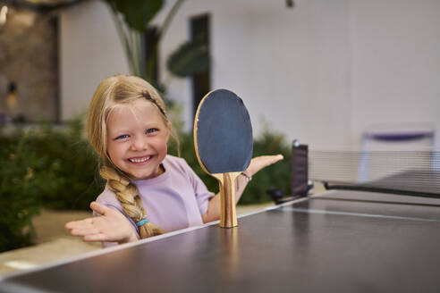 Glückliches Mädchen balanciert Tischtennisschläger in einer Villa - ANNF00819