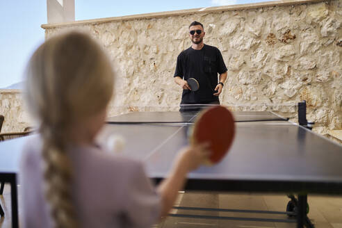 Vater spielt Tischtennis mit Tochter im Urlaub in einer Villa - ANNF00826