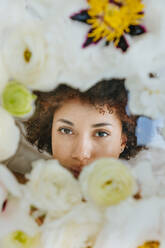 Young woman behind glass surface with flowers - YTF01695