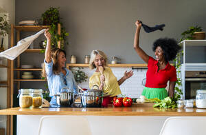 Fröhliche Freunde haben Spaß in der Küche zu Hause - OIPF03840