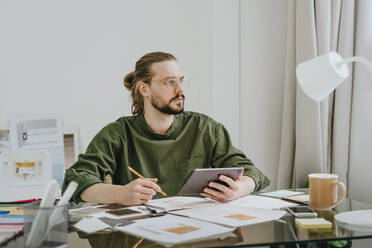 Durchdachter Möbeldesigner mit Tablet-PC am Schreibtisch im Büro - YTF01708