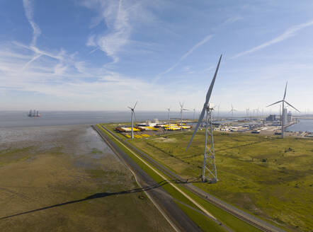 Niederlande, Provinz Groningen, Eemshaven, Luftaufnahme von Windkraftanlagen vor dem Seehafen - MKJF00006