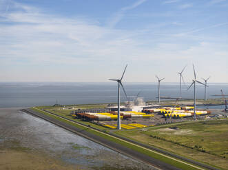 Niederlande, Provinz Groningen, Eemshaven, Luftaufnahme von Windkraftanlagen vor dem Seehafen - MKJF00007