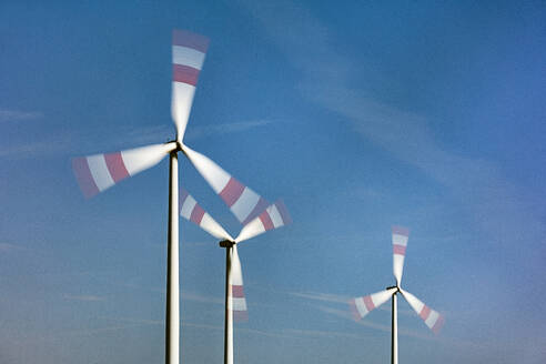 Spinning wind farm turbines in rural landscape - JATF01376