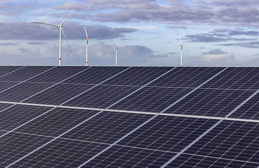 Solar power station with wind farm in background - JATF01379