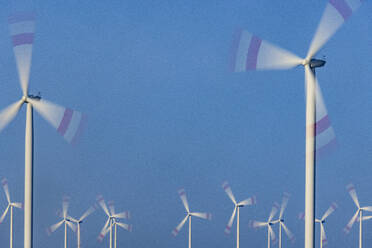 Windpark-Turbinen drehen sich vor blauem Himmel - JATF01384