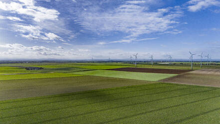 Luftaufnahme von Feldern auf dem Land mit Windpark im Hintergrund - JATF01390