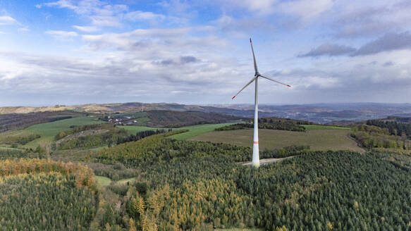 Aerial view of lone wind turbine surrounded by trees - JATF01391