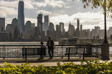 Geschäftskollegen an der Promenade mit der Skyline im Hintergrund - UUF31143