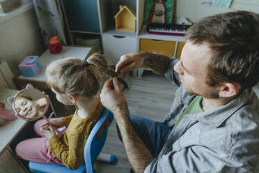 Vater flechtet seiner Tochter zu Hause die Haare - YTF01752