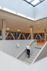 Senior businesswoman standing on staircase - JOSEF23366