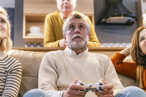 Freunde mit Mann spielen Videospiel zu Hause - PBTF00475