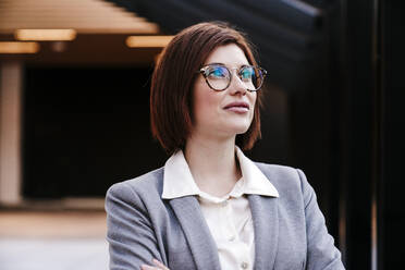 Lächelnde Geschäftsfrau mit Brille im Büro - EBBF08507