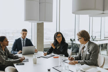 Multiracial business colleagues discussing strategy in board room - MASF42345