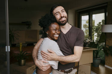 Portrait of happy man embracing girlfriend at new home - MASF42500