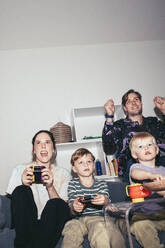Glückliche Familie, die zu Hause ein Videospiel spielt - MASF42538