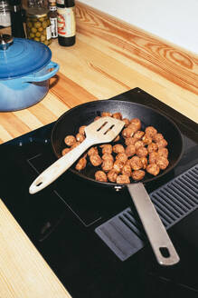 High angle view of meatballs in pan over ceramic stove top at home - MASF42560