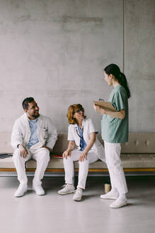 Glückliche multirassische Ärztekollegen diskutieren im Krankenhaus - MASF42600