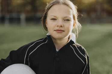 Portrait of elementary girl with soccer ball in sports field - MASF42695