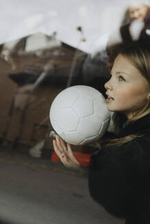 Mädchen mit Fußball Tagträume durch Glas von Auto gesehen - MASF42741