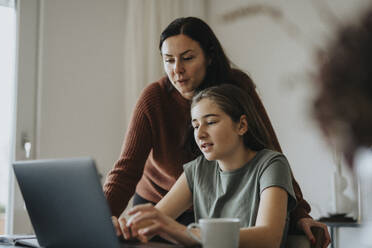 Mädchen mit Laptop bei der Mutter in einem modernen Haus sitzend - MASF42872