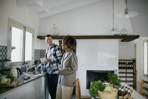 Glückliche Freunde, die sich in der Küche zu Hause unterhalten - MASF42875