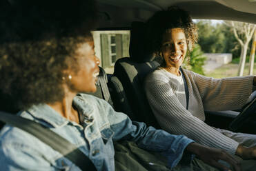 Glückliche junge Frauen sitzen im Auto - MASF42988