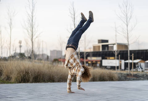 Mann macht Handstand auf dem Gehweg - JCCMF11171