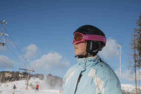 Girl wearing sports helmet at ski resort - OSF02392