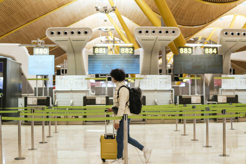 Young man with luggage walking at airport - PBTF00489