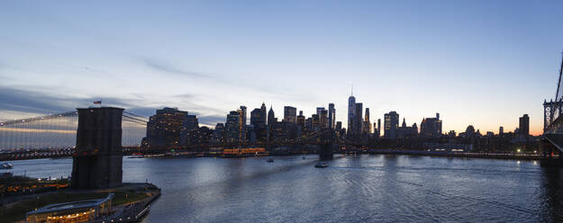 USA, New York State, New York City, Panoramic view of Brooklyn Bridge and Manhattan skyline at dusk - NGF00823