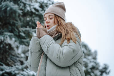 Woman warming up hands in winter - NLAF00245