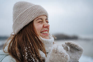 Happy woman laughing with eyes closed in winter - NLAF00272