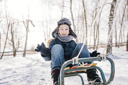 Happy boy sledding on snow in winter - NLAF00286