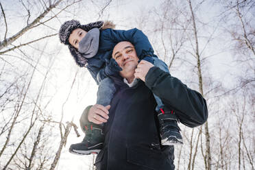 Lächelnder Vater trägt seinen Sohn im Winter auf den Schultern - NLAF00290