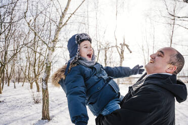 Vater und Sohn genießen gemeinsam den Schnee im Winter - NLAF00291