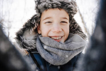 Glücklicher Junge mit Jägermütze im Winter - NLAF00293