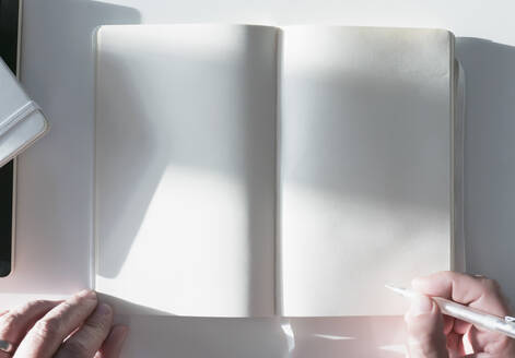 Man Holding Pencil over Blank Page of a Notebook - FSIF06805