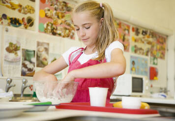 Young girl in cookery class kneading - FSIF06807