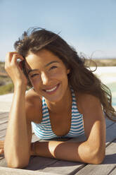 Beautiful young woman wearing bikini lying on beach stock photo