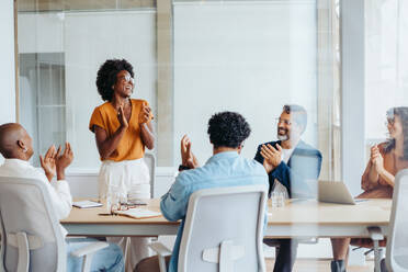 Group of business people applauding and celebrating their successful teamwork, showcasing the spirit of collaboration and success in the workplace. Diverse business professionals working in a startup. - JLPSF31147