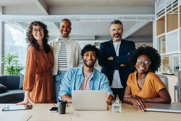 Group of business people smiling in a team portrait. The team is composed of business men and women. They are happy, successful, and work together with creativity and technology in an office. - JLPSF31186