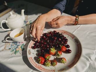 Ältere Frau mit Beeren und Tee zu Hause - IEF00536