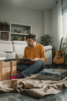 Der Mann mit der altmodischen Vinylplatte und dem Plattenspieler zu Hause - DMGF01214