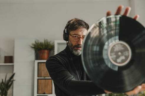 Man listening to music and analyzing vinyl at home - DMGF01243