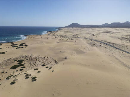 Weitläufiger Blick auf die Dünen von Corralejo und das blaue Meer vor der Kulisse der Berge auf Fuerteventura - ADSF52859