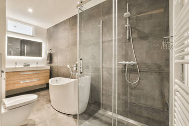 A sleek and contemporary bathroom layout featuring a walk-in shower, wall-mounted sink, and minimalist design. - ADSF52912